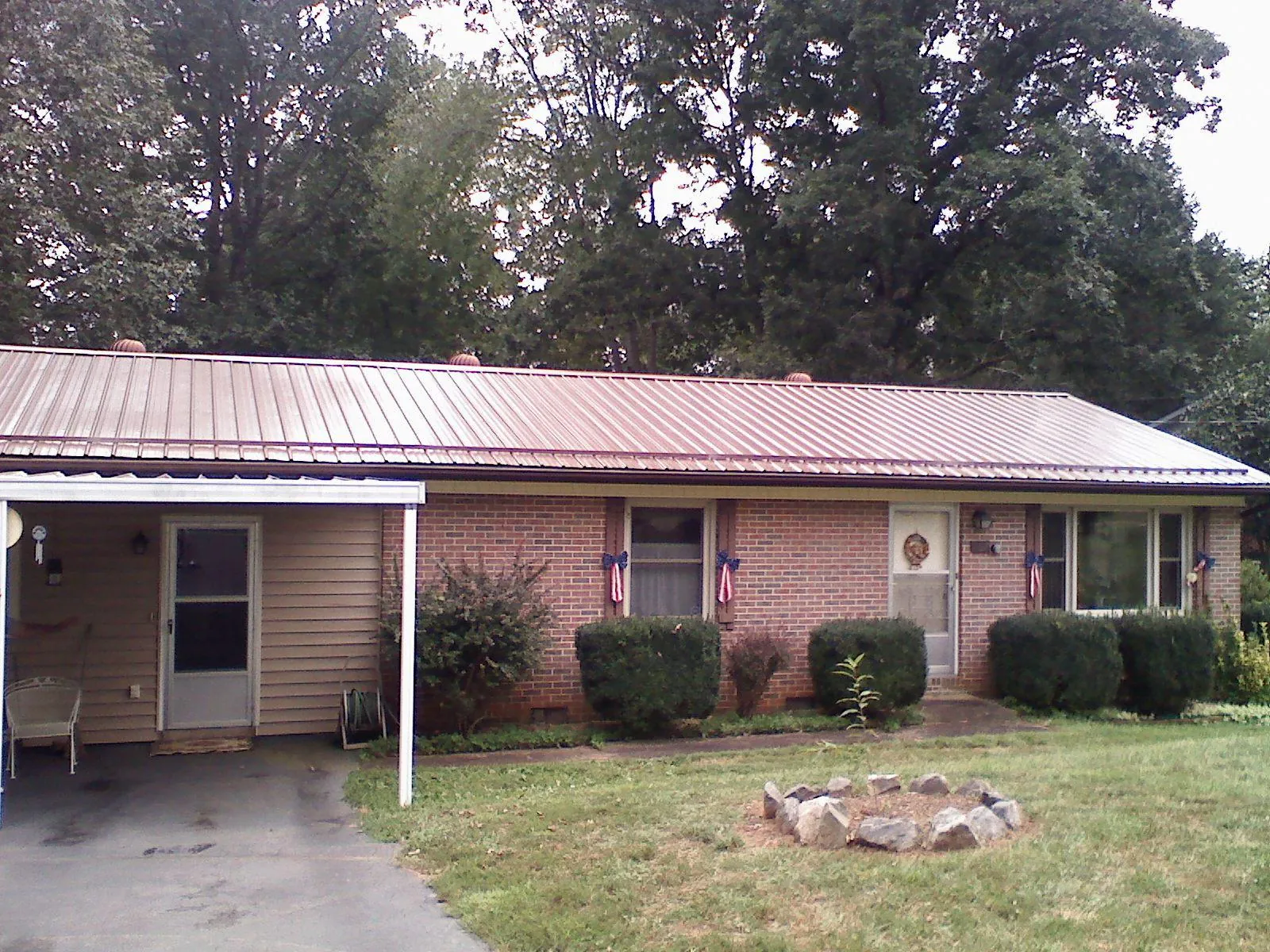 Bronze metal roof and carport on a brick ranch home — Roof Repair work by our crew in Hayes